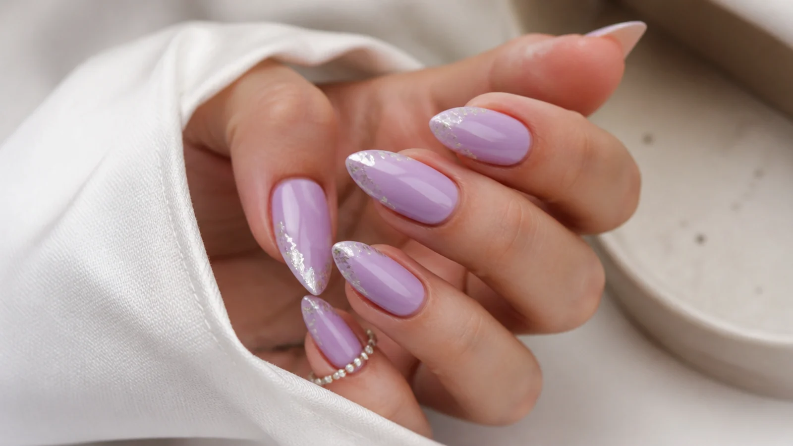 Light purple almond nails with delicate silver foil-flecked tips