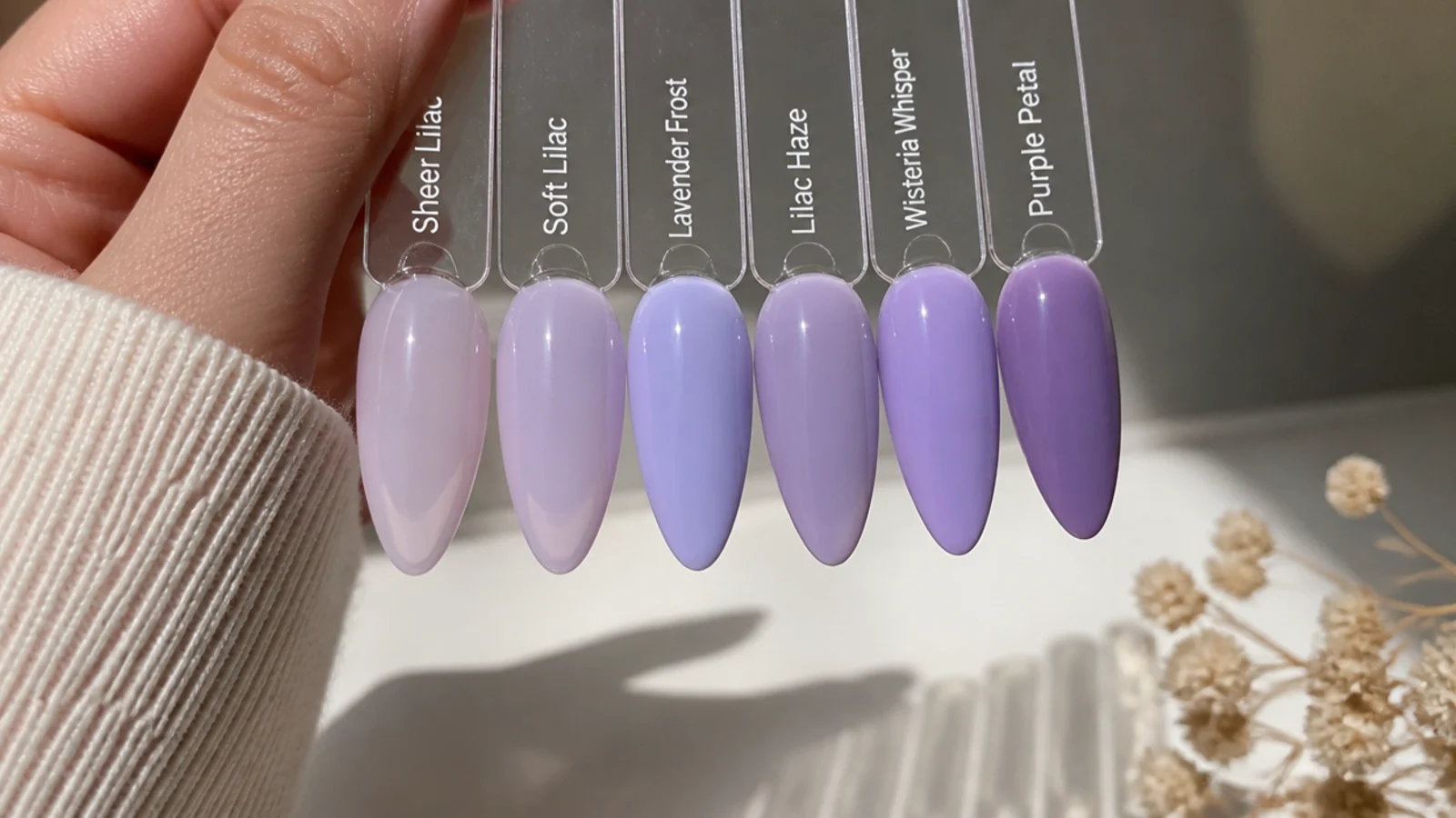 Light purple gel swatches building from sheer to opaque on almond nail tips