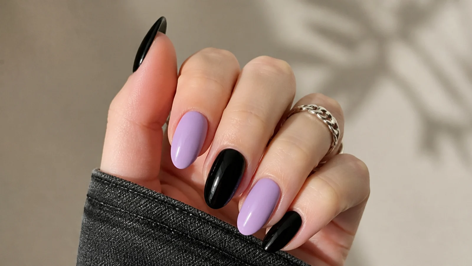 Alternating solid lilac and glossy black nails across one hand