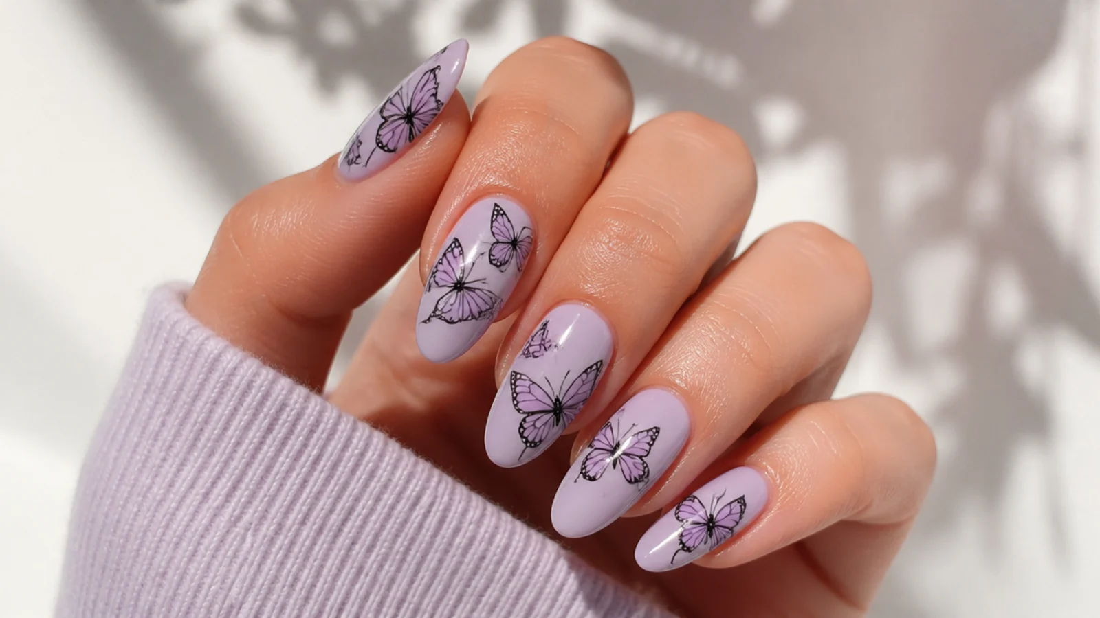 Light purple nails with delicate black outlined butterfly art
