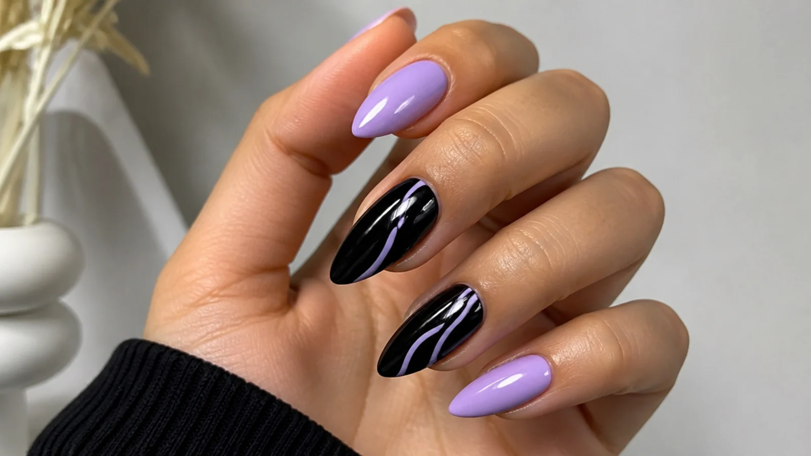 Soft lilac and glossy black nails in a high-contrast almond set