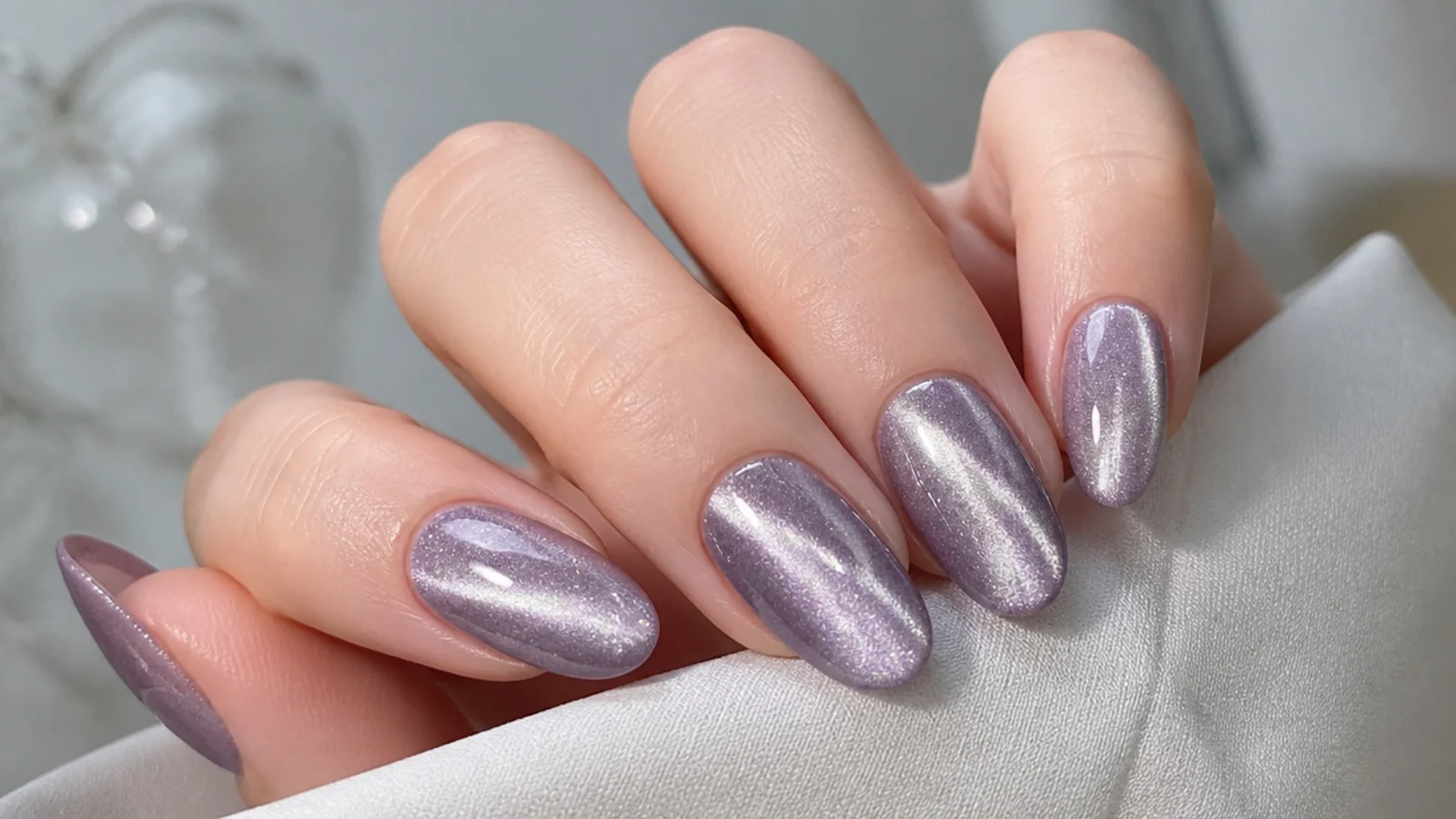 Cool silvery light purple cat eye nails with a bright icy beam on fair skin