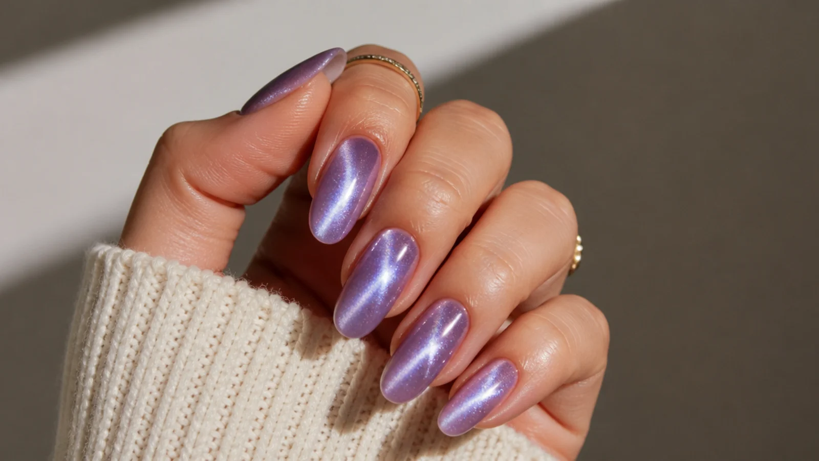 Light purple cat eye nails with a bright shifting magnetic beam on an almond shape