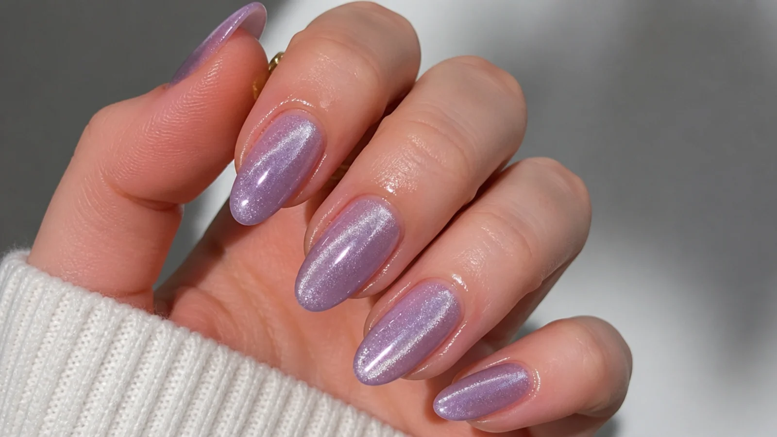 A well-sealed light purple cat eye manicure with cuticle oil for longevity