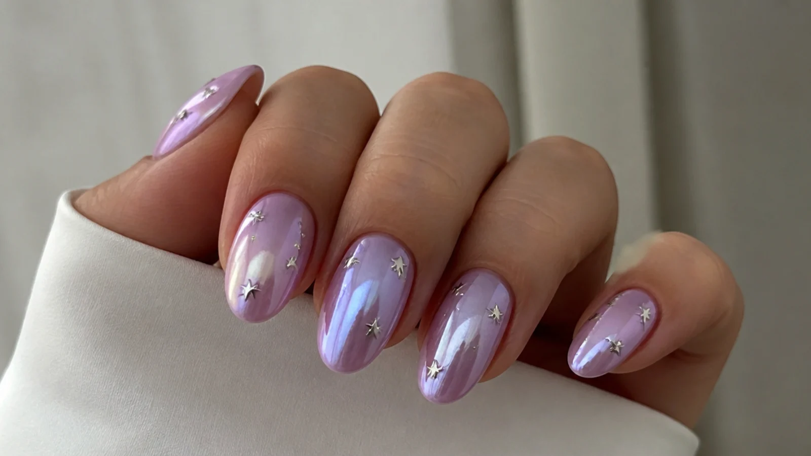 Lilac chrome nails with tiny silver star decals scattered on top