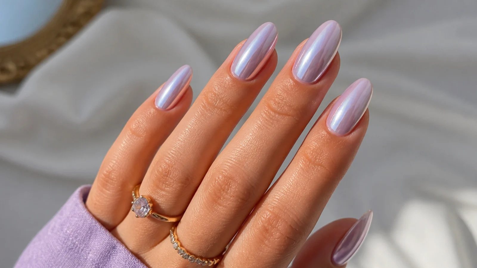 Shiny light purple chrome nails with a lilac mirror finish on an almond shape