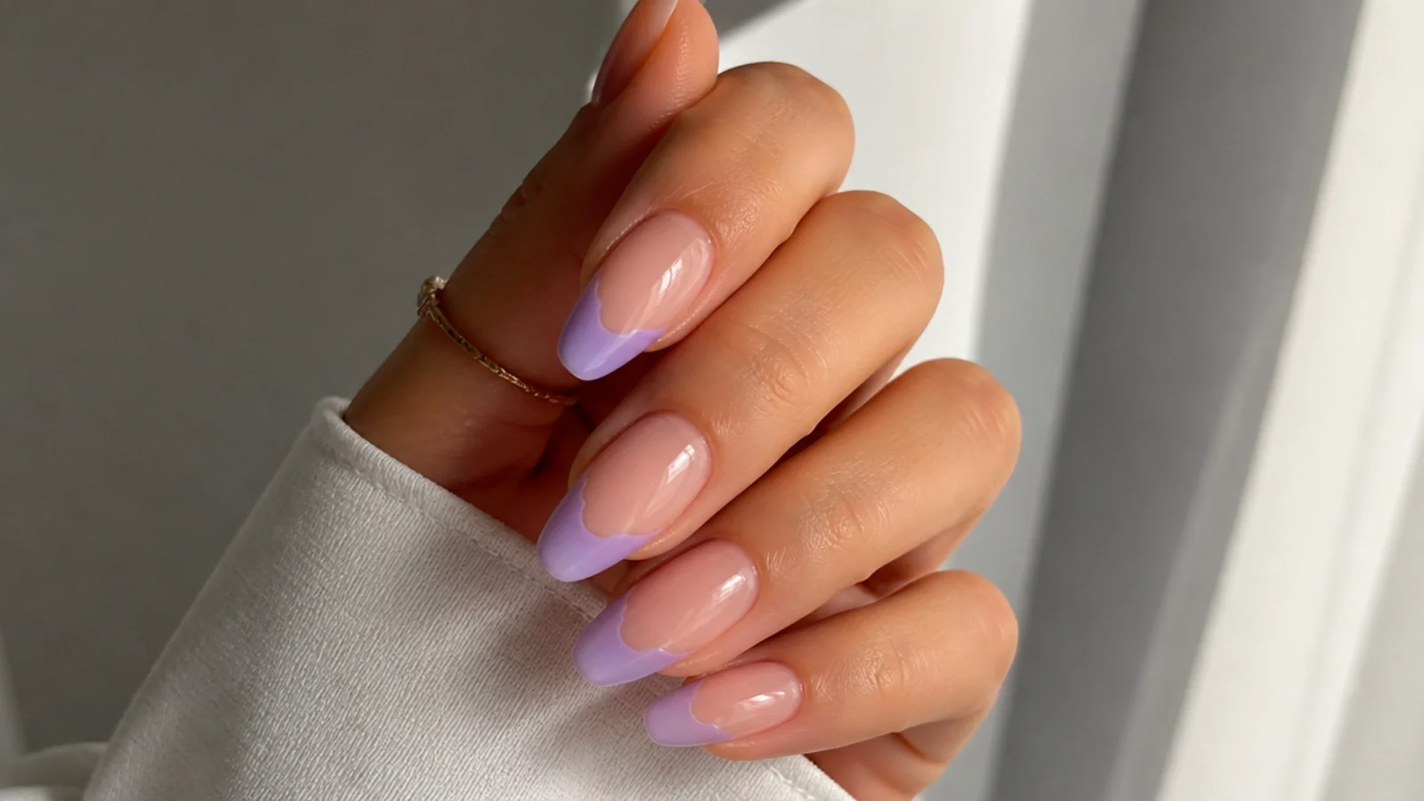Soft milky lilac french tip nails on a sheer almond shape