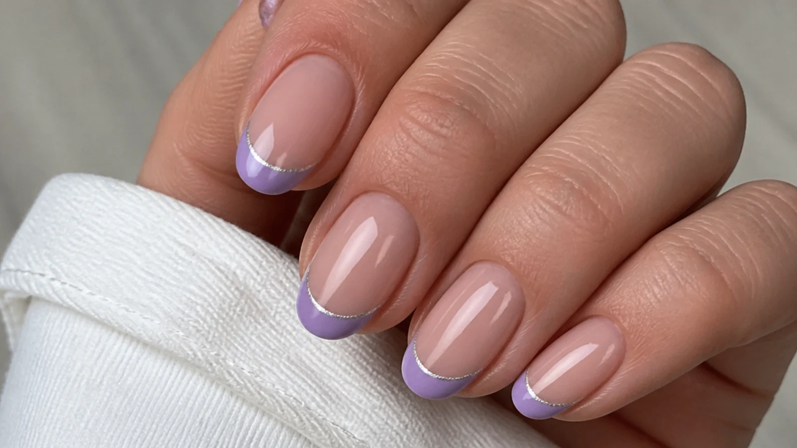 Light purple french tips edged with a thin silver line on nude nails