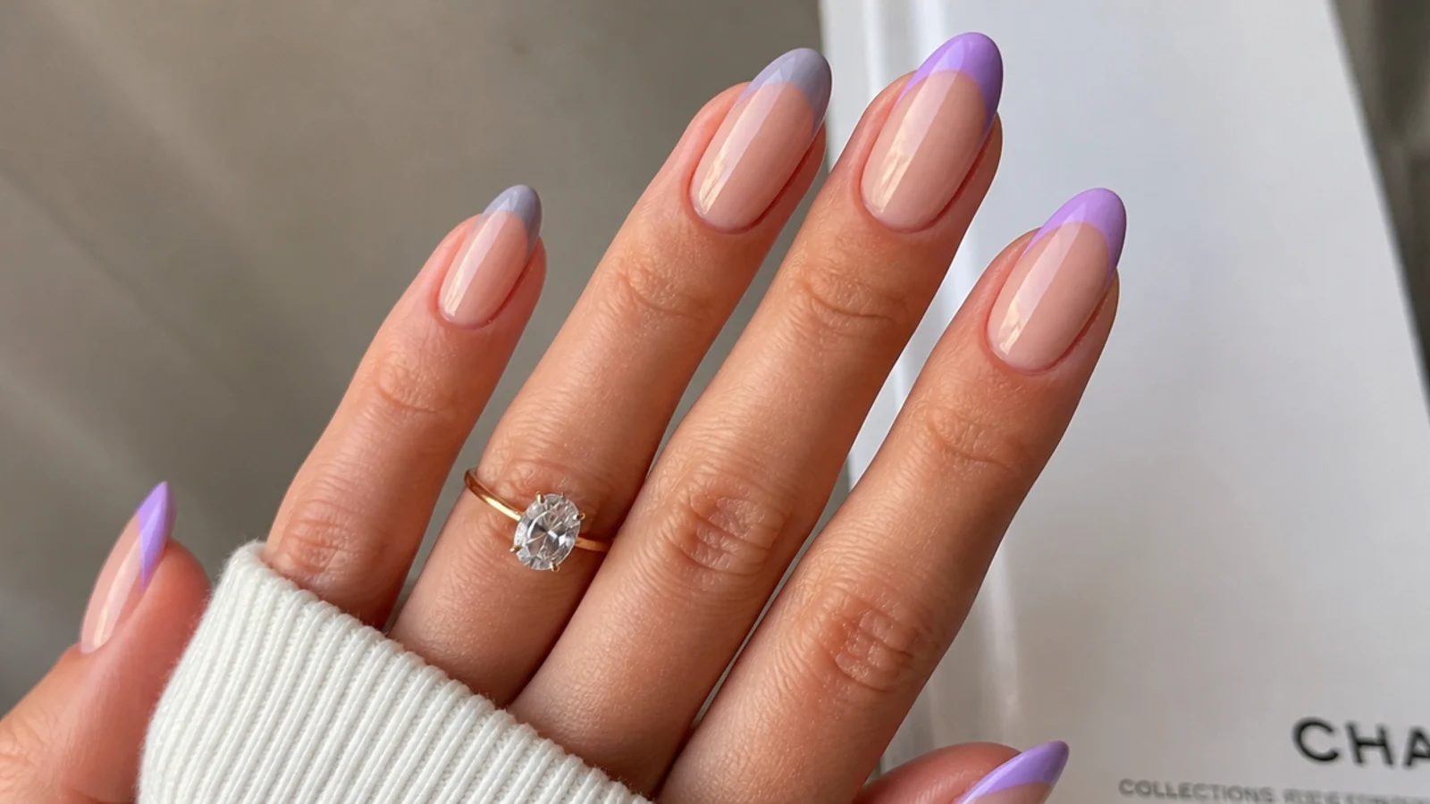A grayed lavender french tip beside a brighter lilac french tip on nude nails