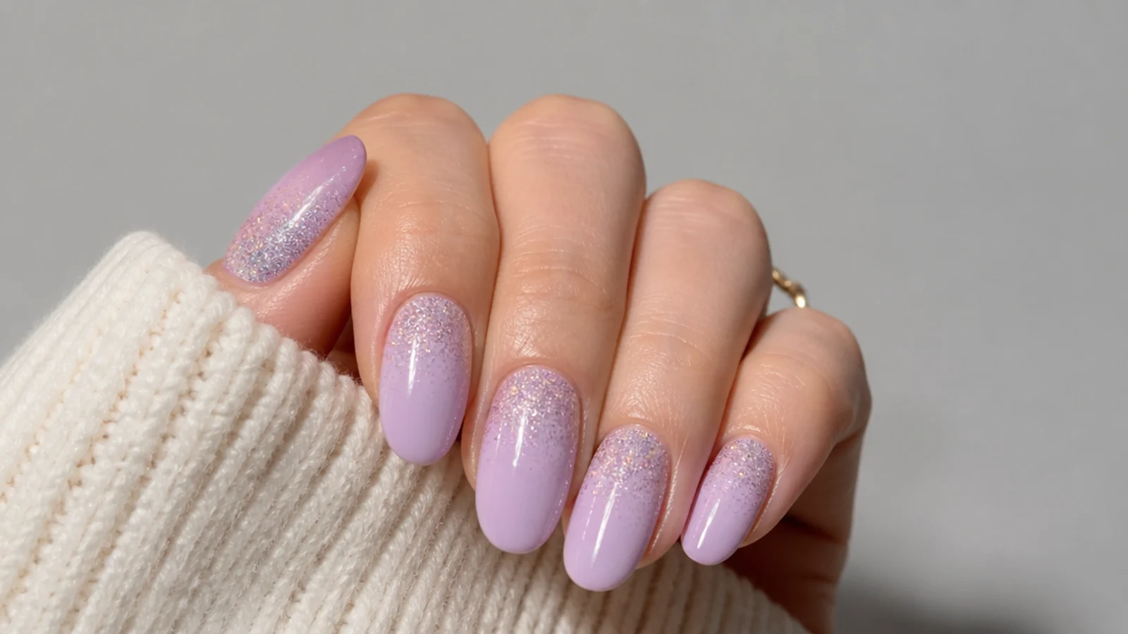 Pastel light purple nails with a soft glitter gradient from cuticle to tip