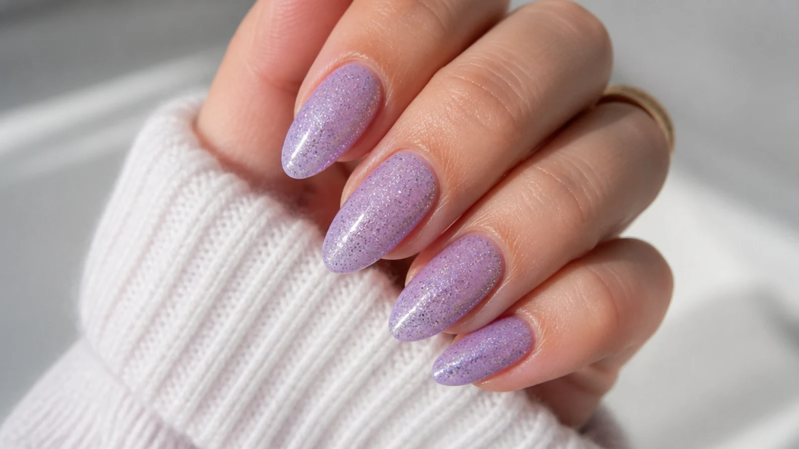 Light purple lilac nails with fine silver glitter on an almond shape