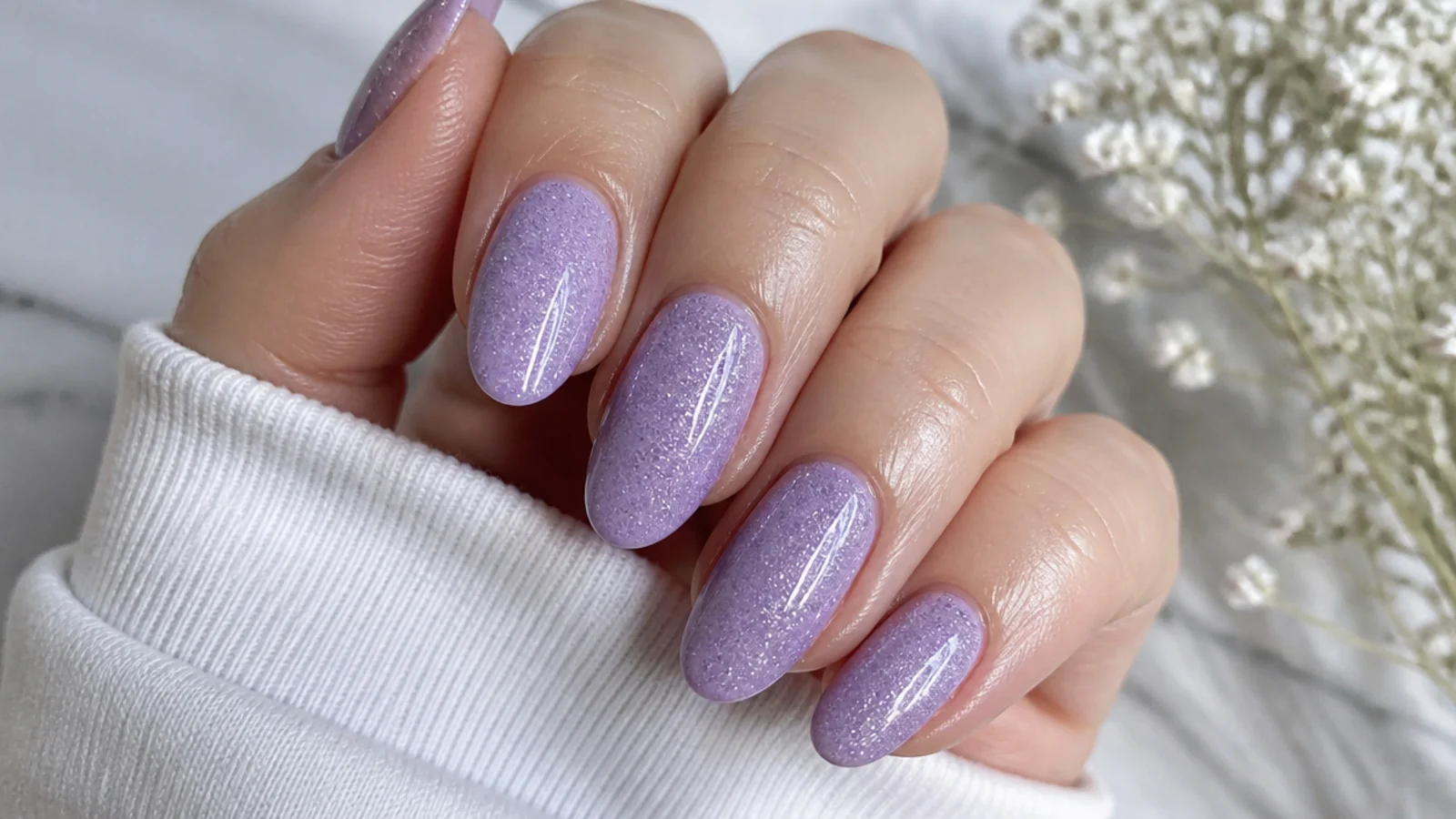A well-sealed light purple glitter manicure with cuticle oil for longevity