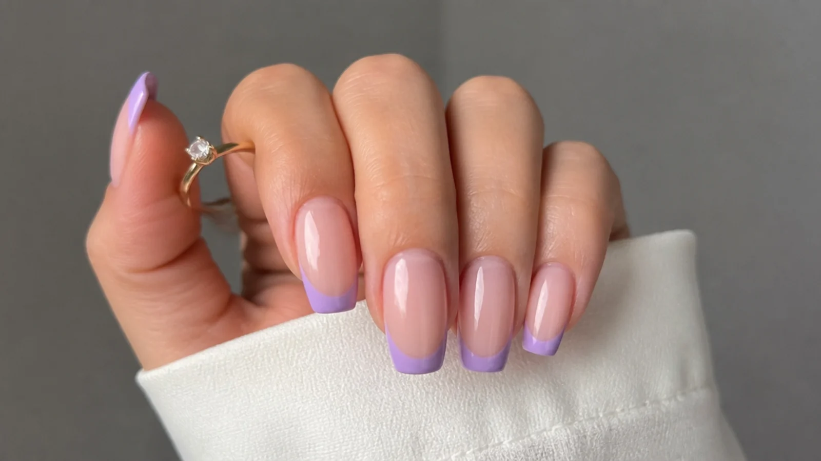 Soft lavender French tip nails on a sheer nude base