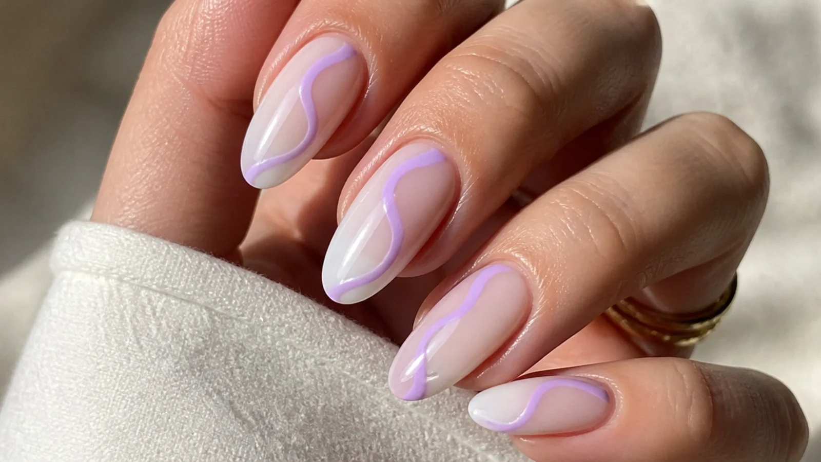Milky nails with soft light purple swirl lines across the nail
