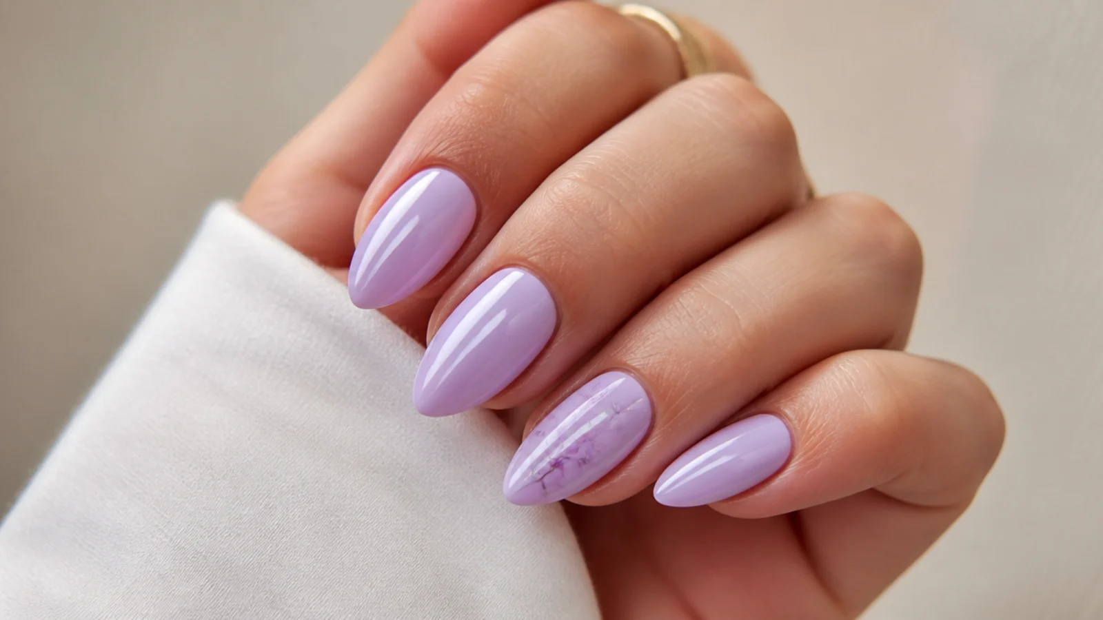 Soft light purple almond nails in a milky lilac shade on a neutral background