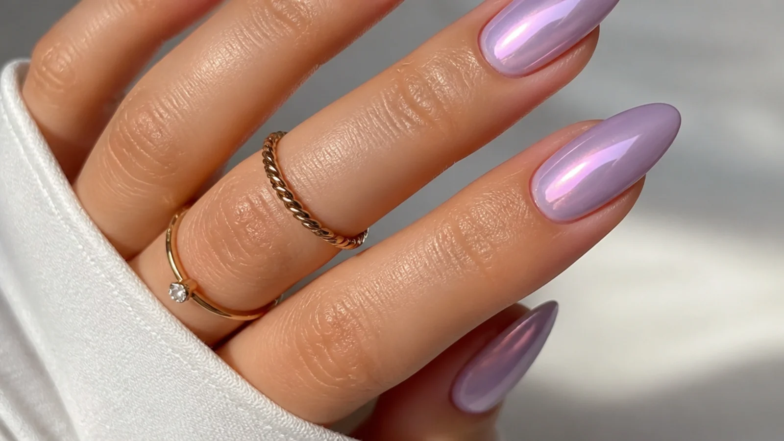 Light purple almond nails with a soft glowing chrome center