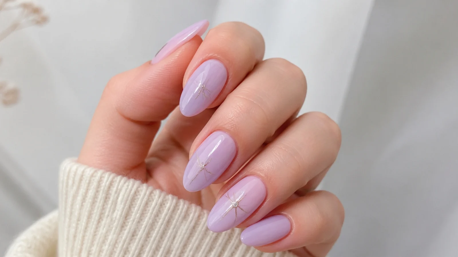 Soft milky light purple almond nails on a light background