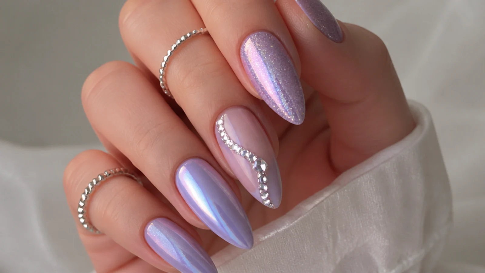 Long light purple prom nails with chrome, glitter and a rhinestone accent