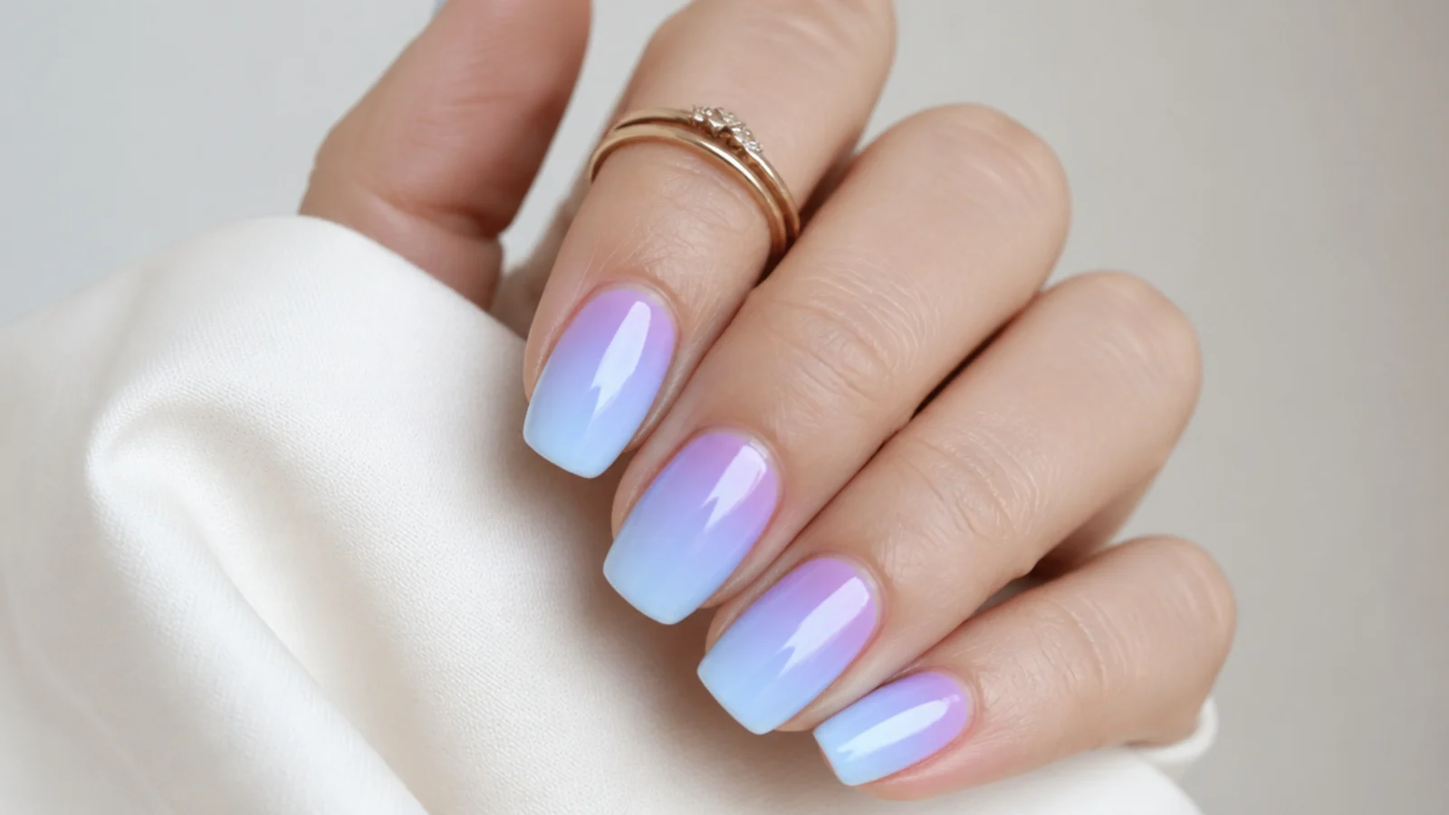 Soft light blue fading into lilac ombre nails on a squoval shape