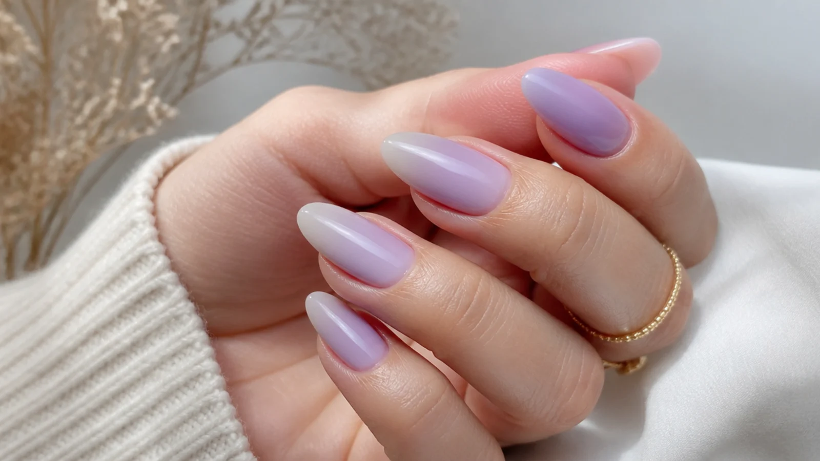 Soft lilac to white ombre nails on an almond shape with a milky fade