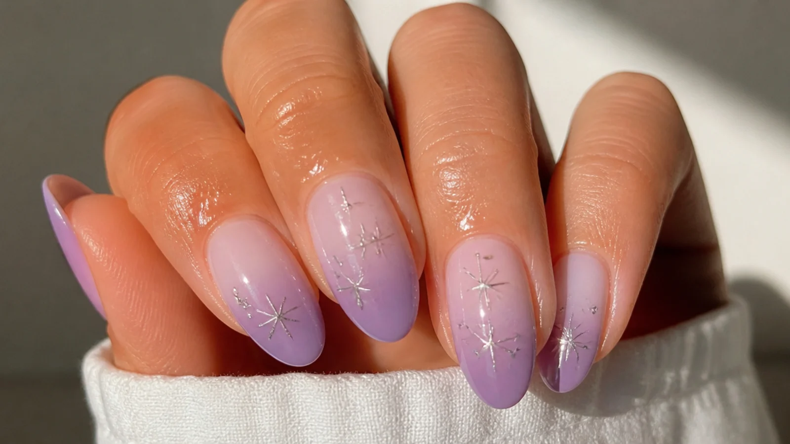 A well-sealed light purple ombre manicure with cuticle oil for longevity