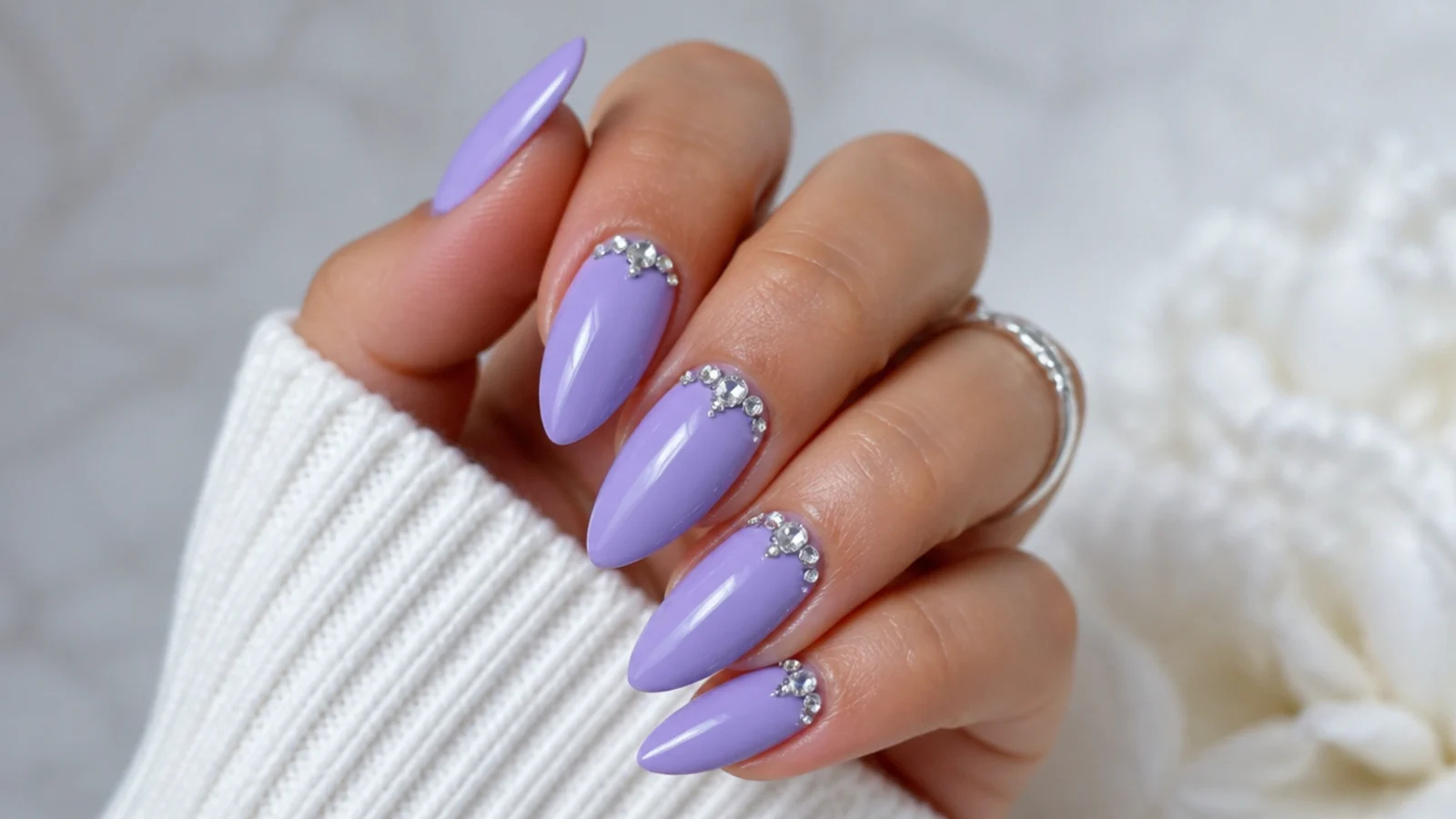 Lavender nails with a cluster of silver rhinestones near the cuticle