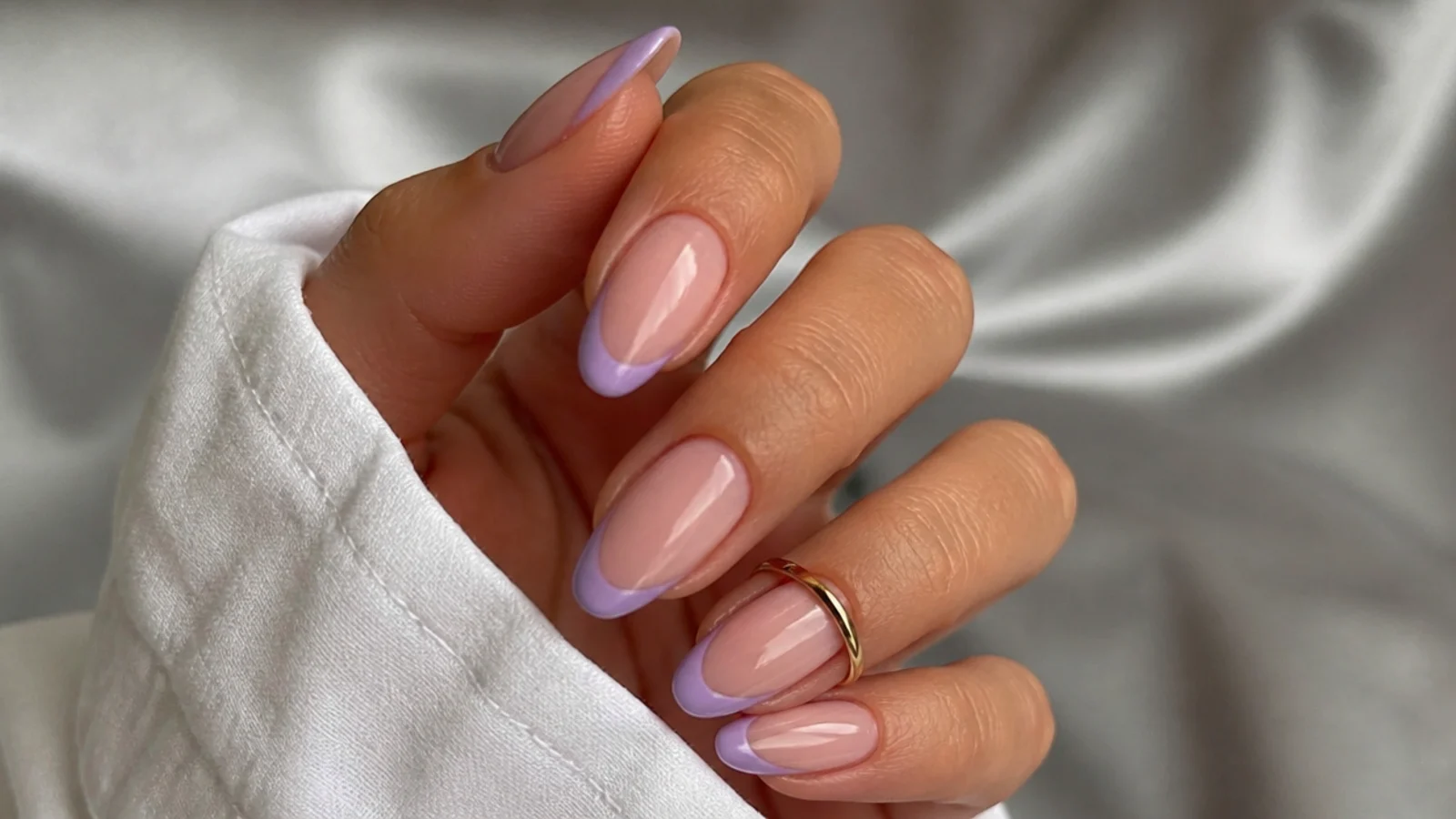 Nude nails with lilac chrome French tips on almond nails