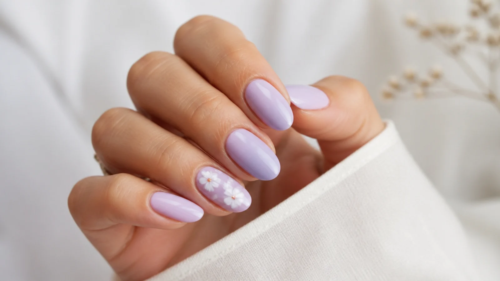 Milky light purple nails with small white hand-painted flowers on one nail