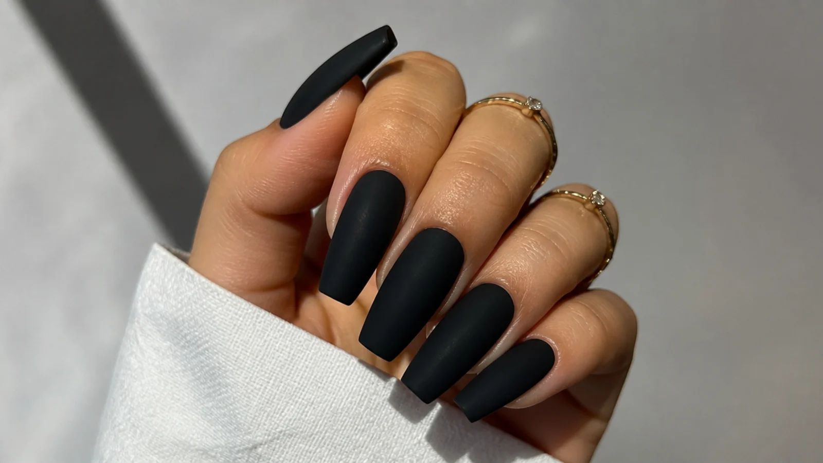Deep matte black nails with a soft velvety finish on a coffin shape
