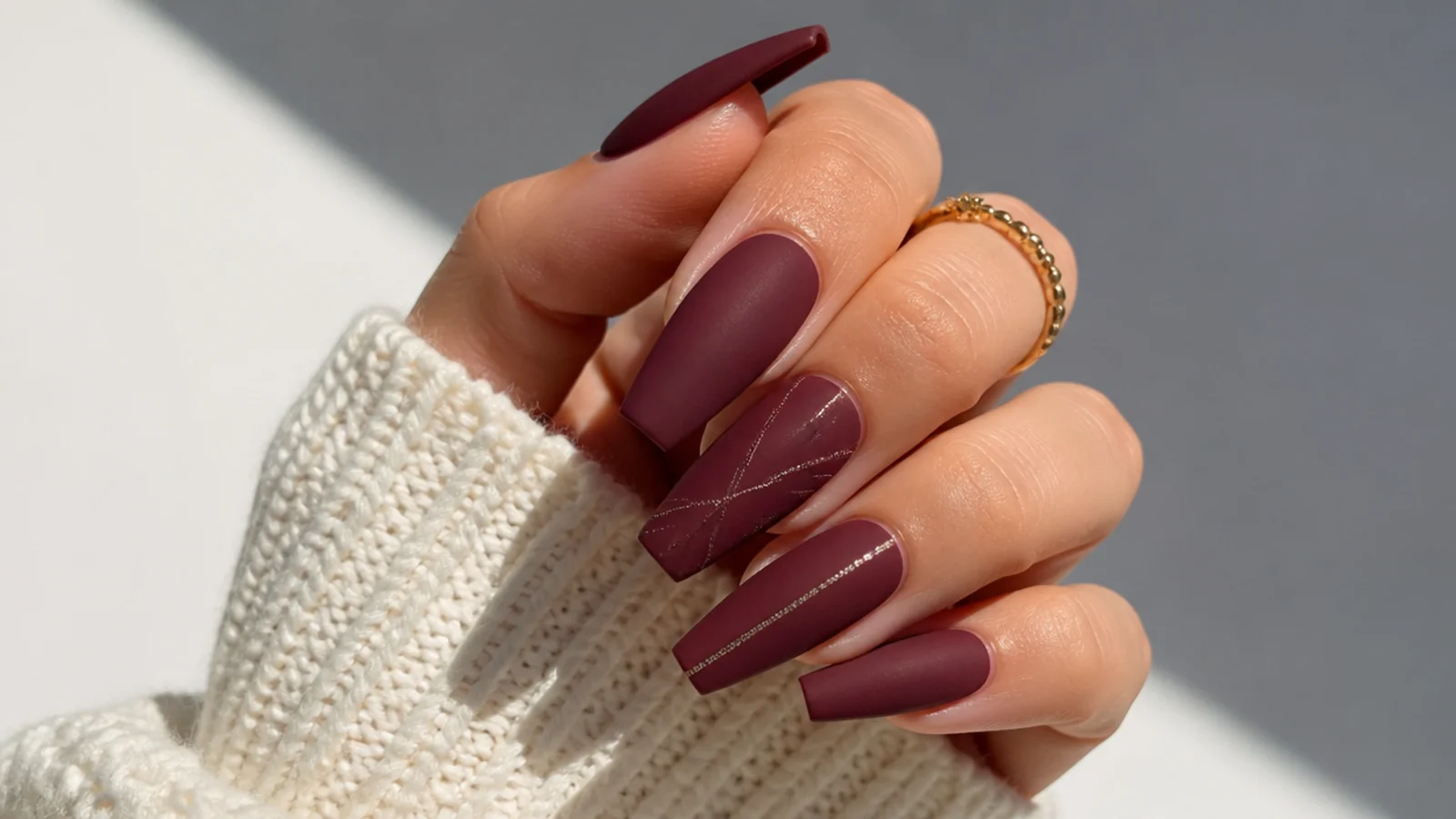 Matte burgundy wine nails on a long coffin shape