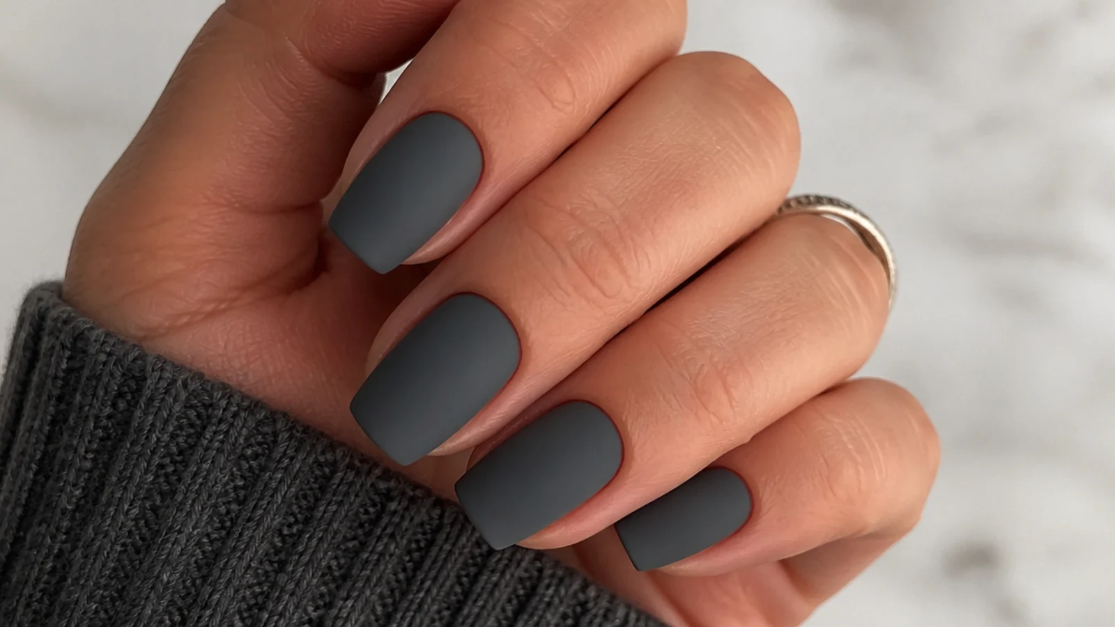 Muted matte slate gray nails on a squoval shape