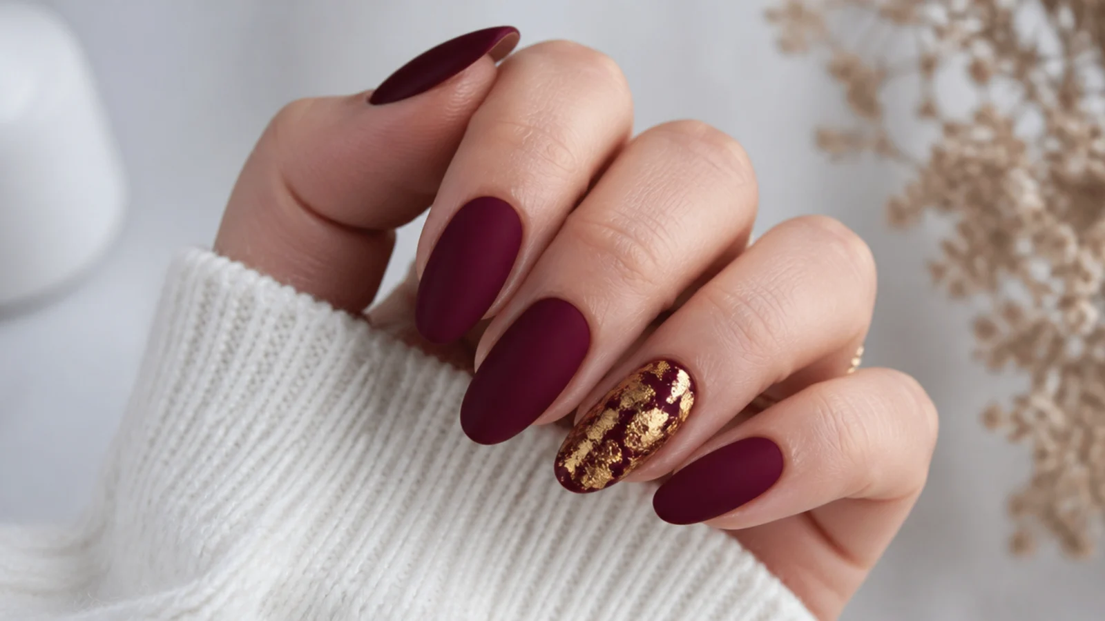 Matte oxblood nails with one glossy gold foil accent nail