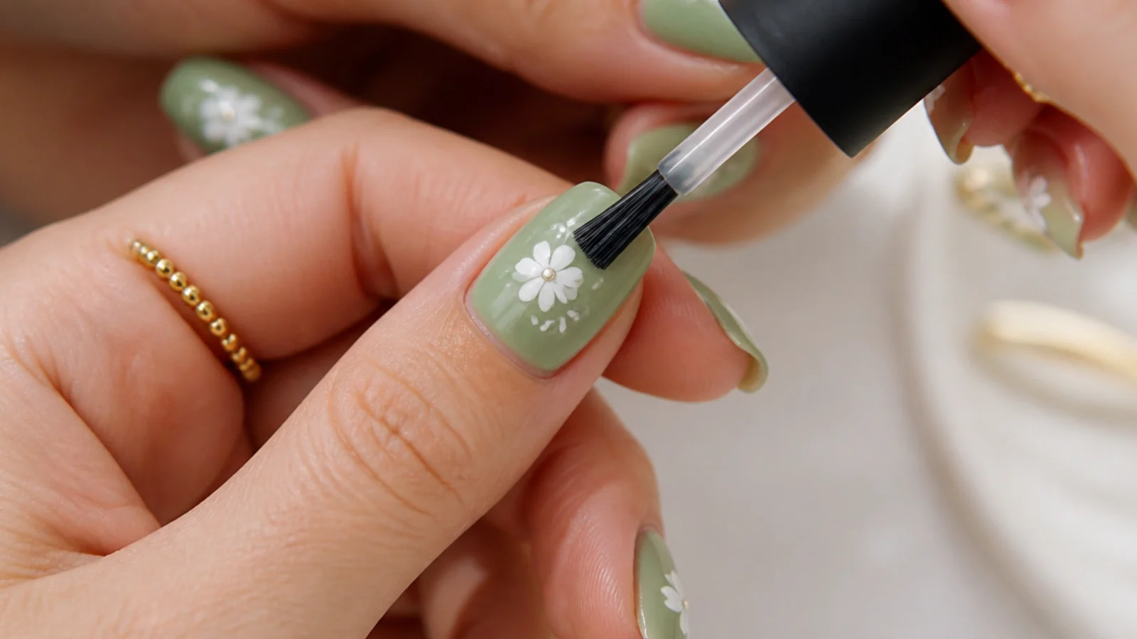 A matte top coat being brushed over a cured colored gel nail