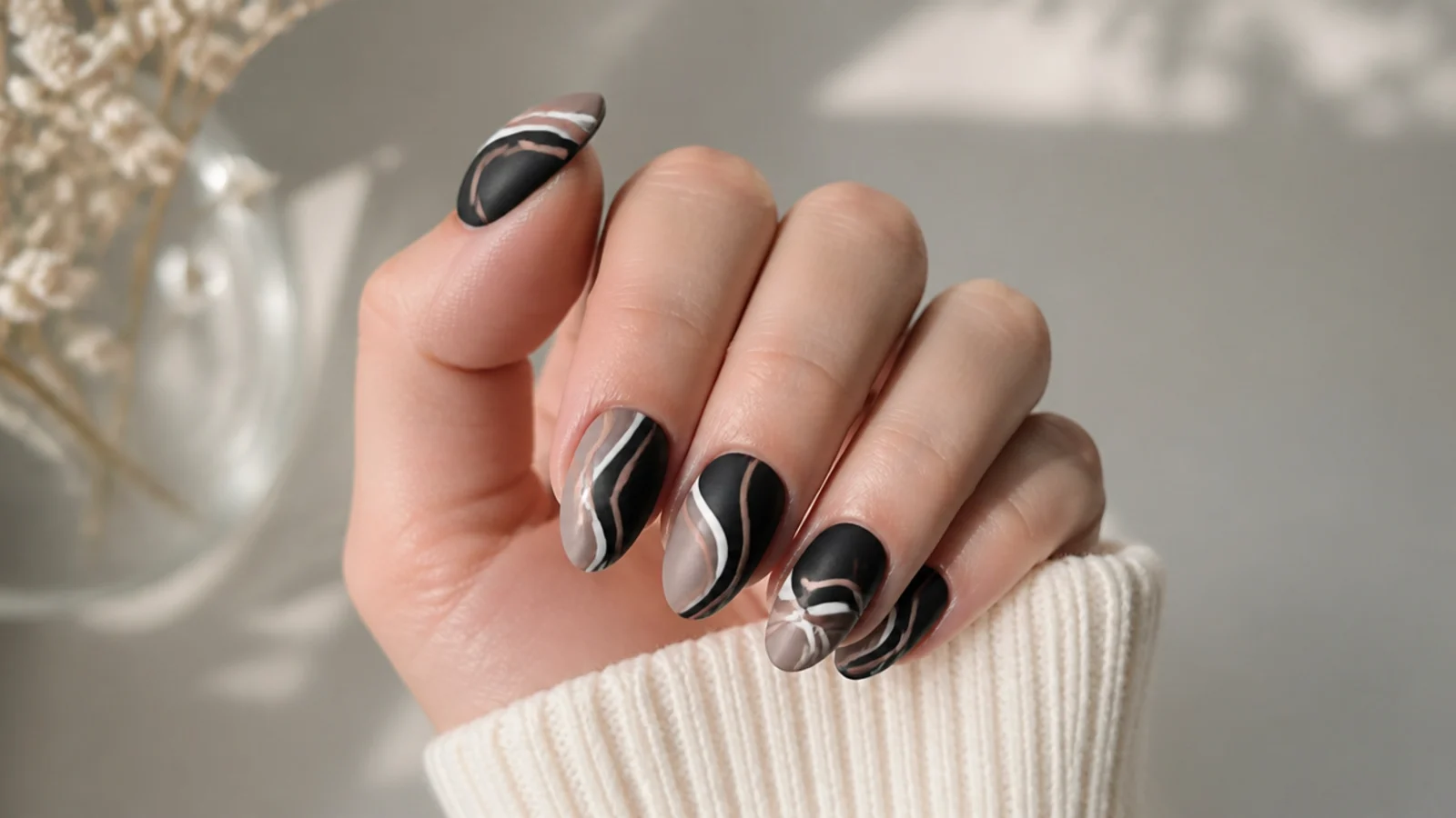 Matte black nails with white and nude abstract swirl lines