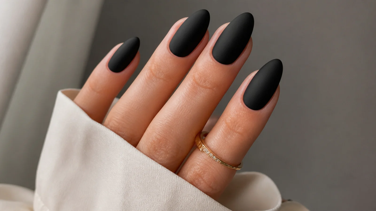Velvety matte black nails on an almond shape with no shine