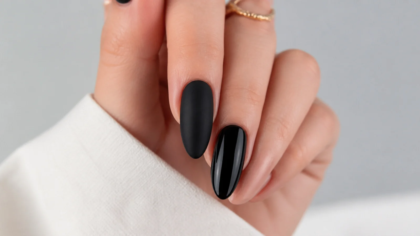 One matte black nail beside one glossy black nail for comparison