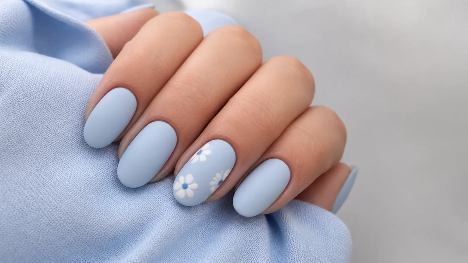Pale matte powder blue nails on a short almond shape