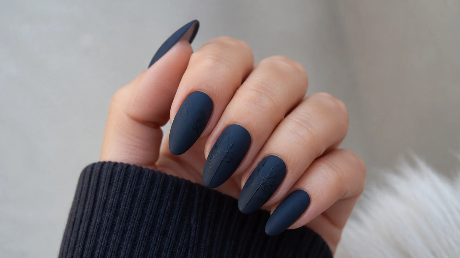 Blue-black matte nails on long almond shape with a deep tone