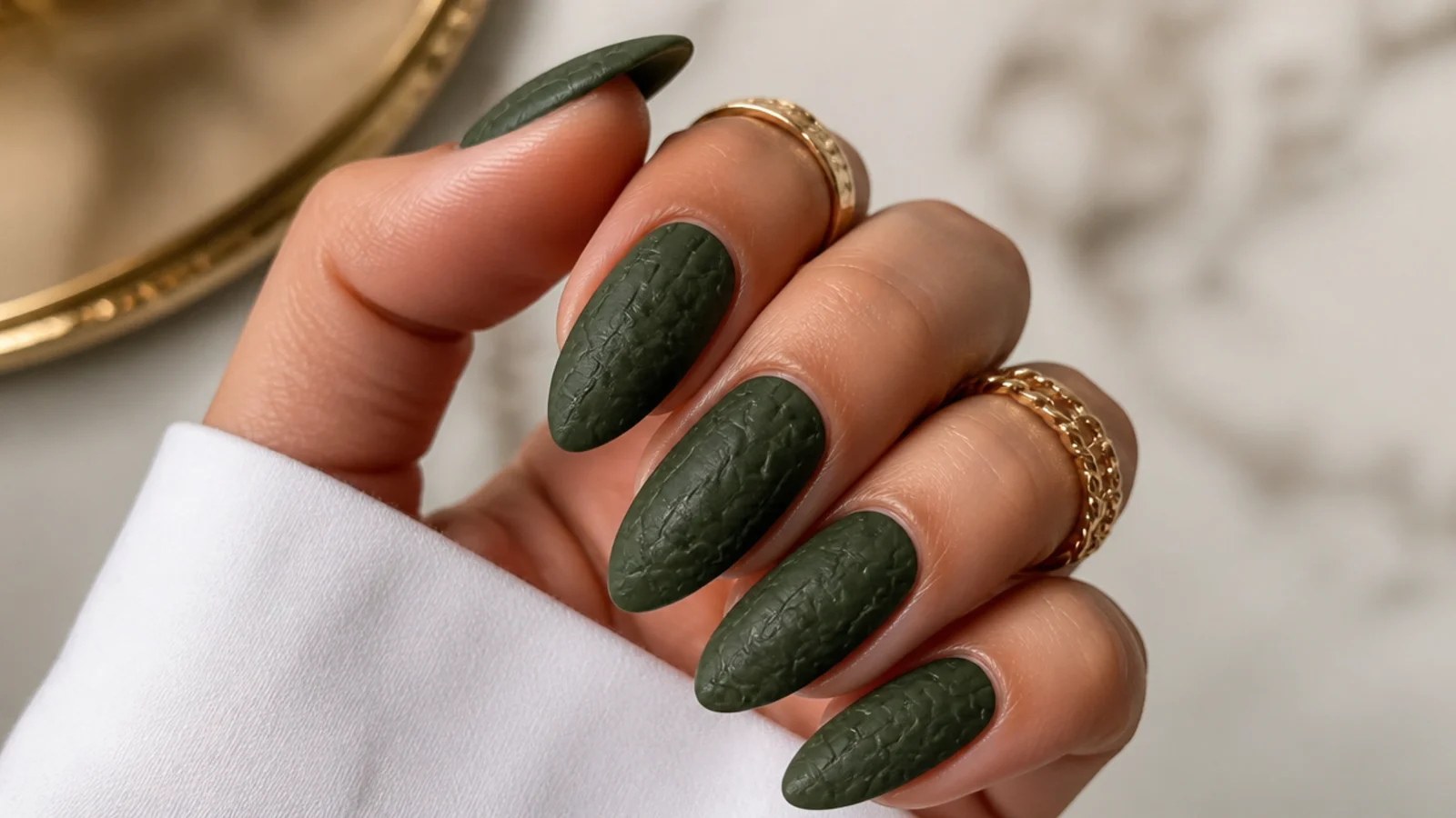 Matte forest green croc-texture nails with tonal scale pattern on almond nails