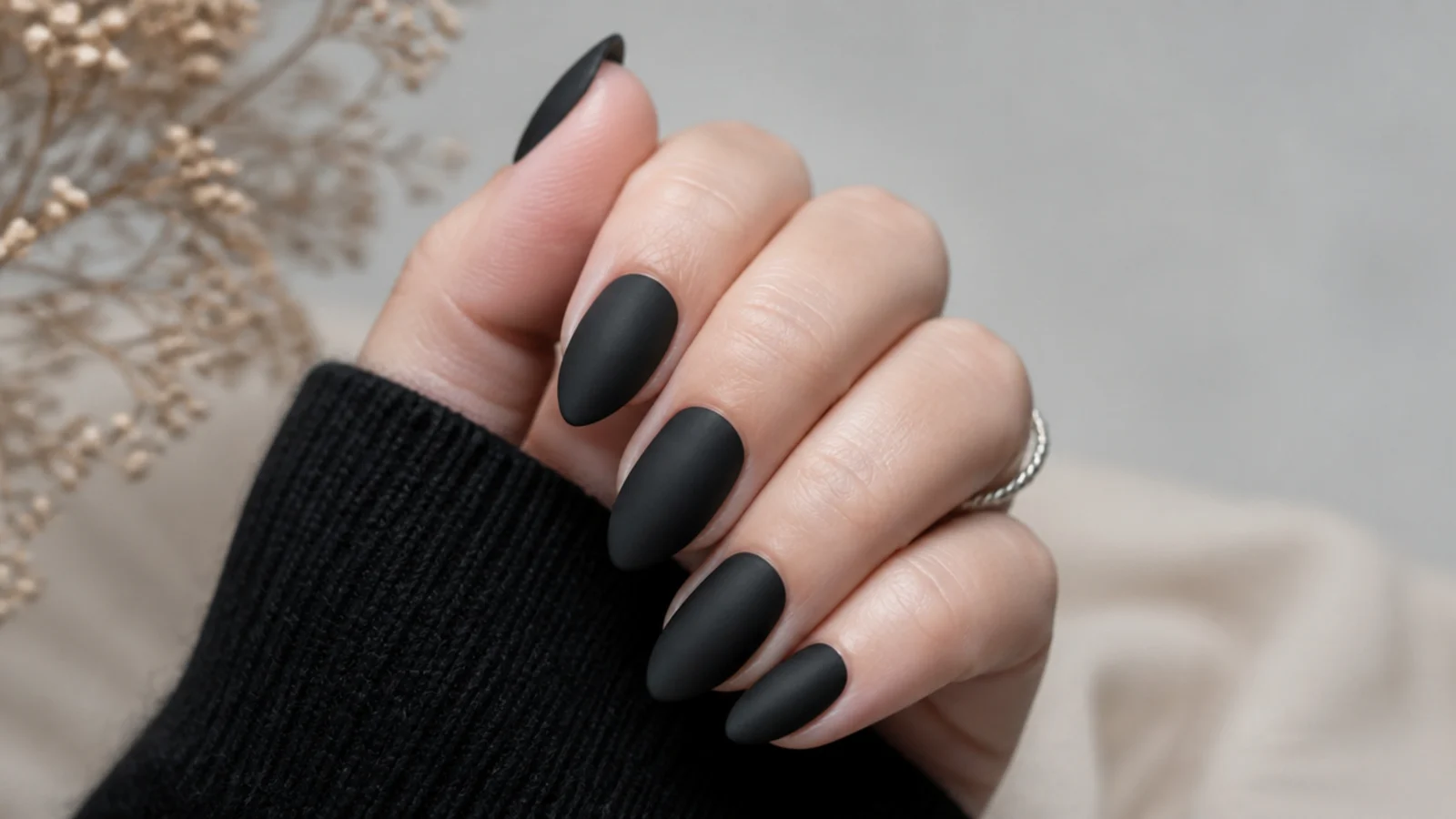 Soft velvety matte black almond nails with a non-shiny finish