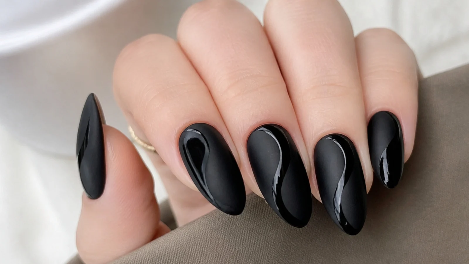 Black nails half matte and half glossy in a swirl pattern