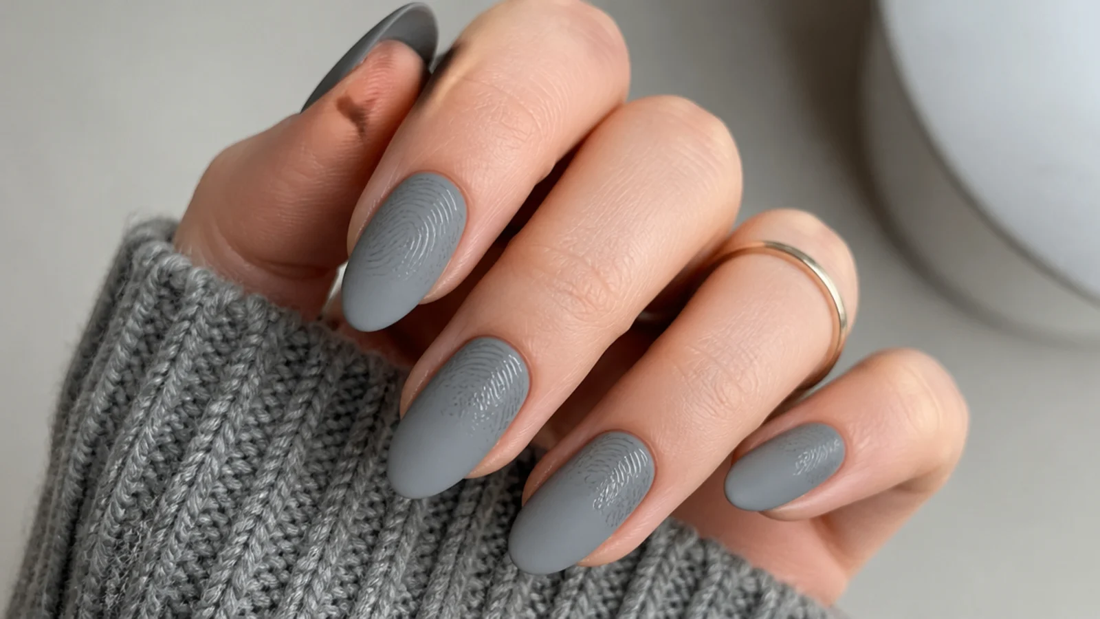 Matte gray nails showing shiny fingerprint marks pressed into the finish