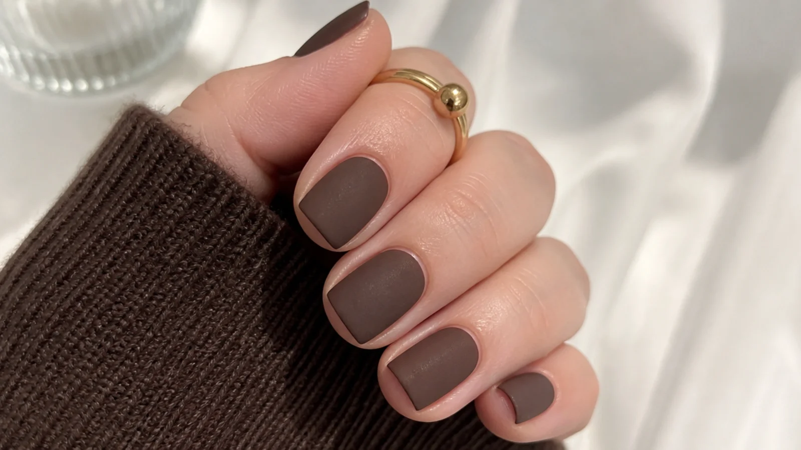 Short squoval nails in matte chocolate brown with a cocoa-suede finish