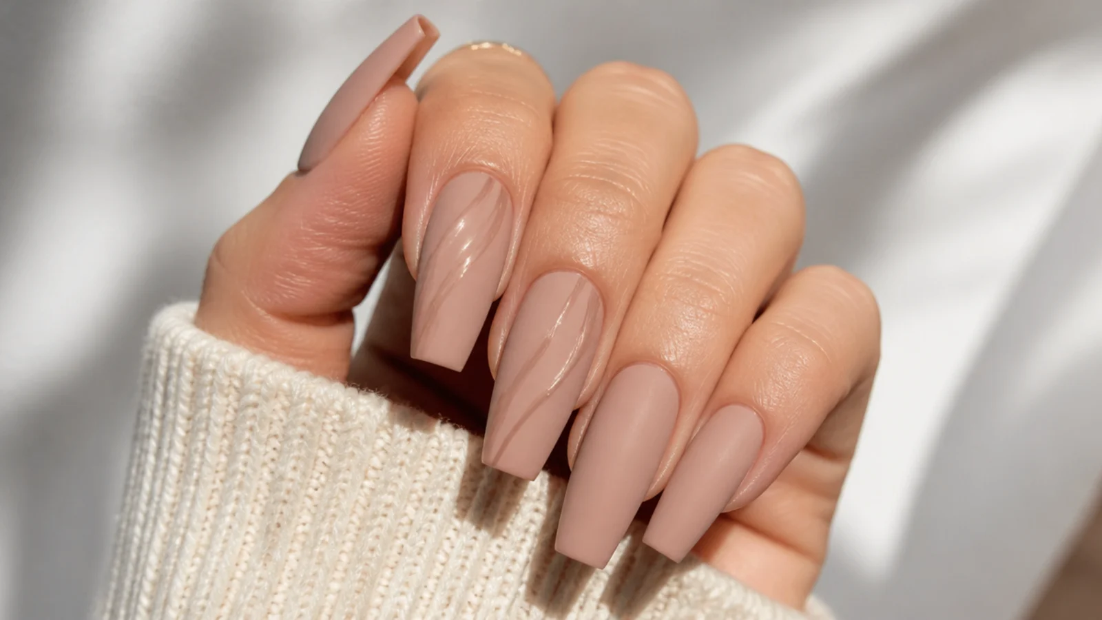 Coffin nails in matte nude with a glossy clear swirl accent catching light
