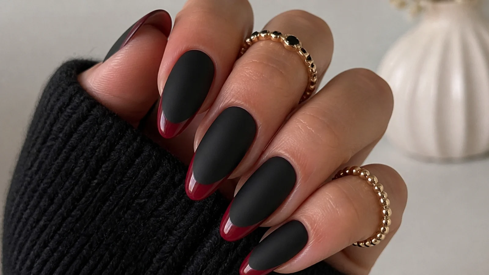Matte black nails with deep red French tips on almond shape