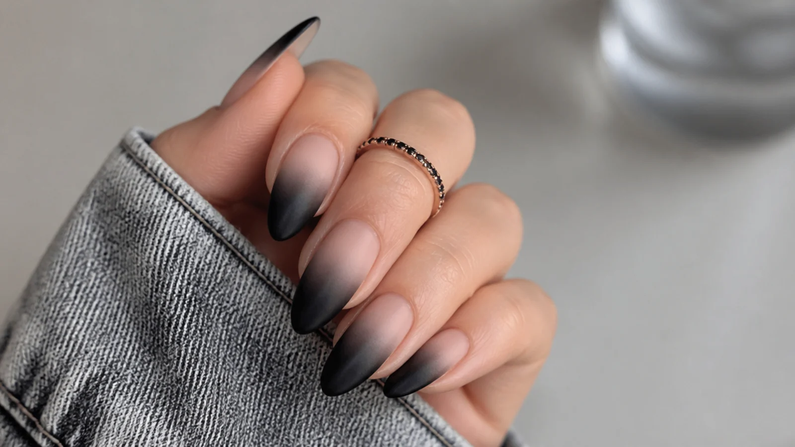 Matte ombre nails fading from black at the tip to nude at the base