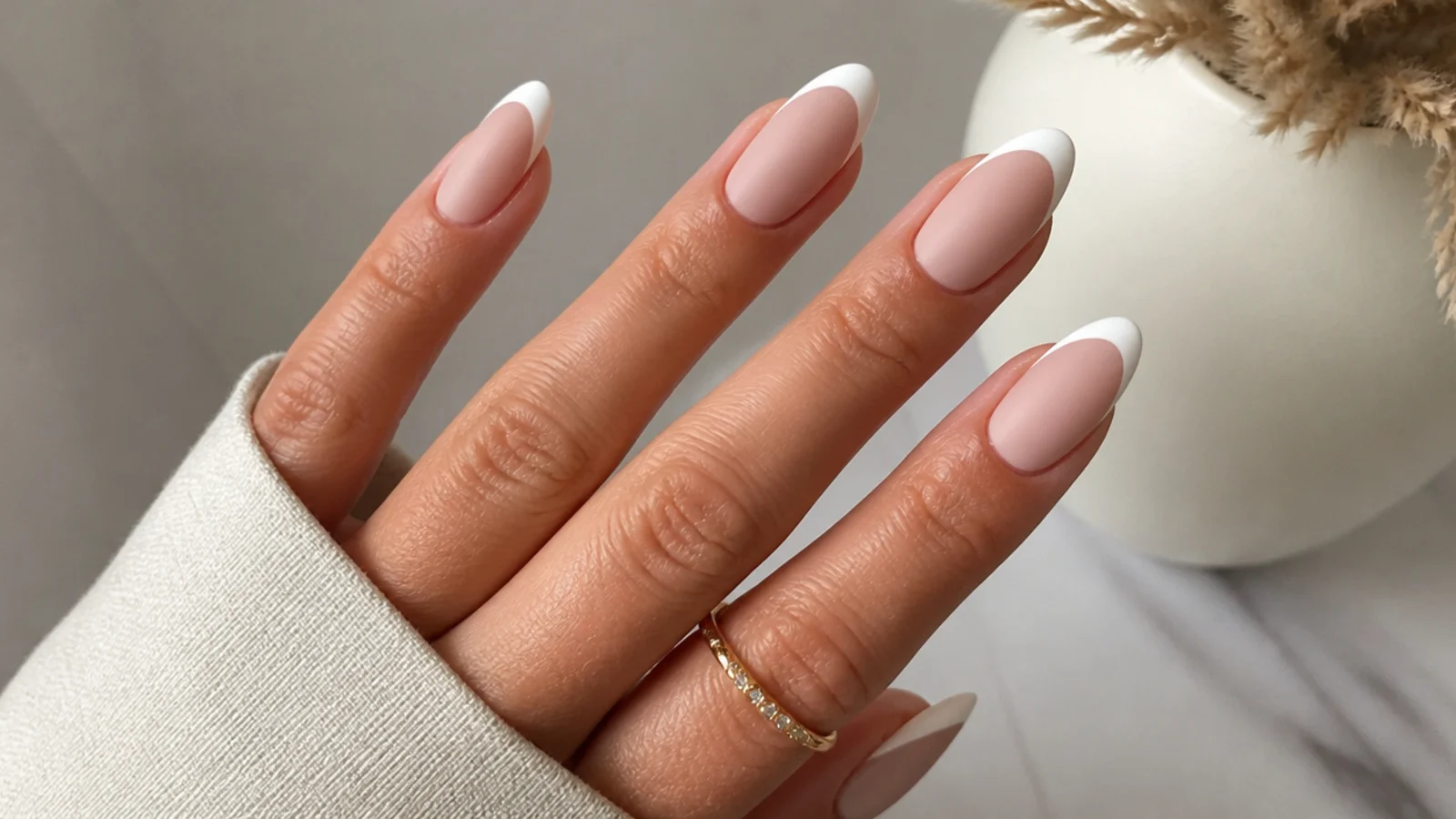 Matte nude nails with soft white French tips on almond shape