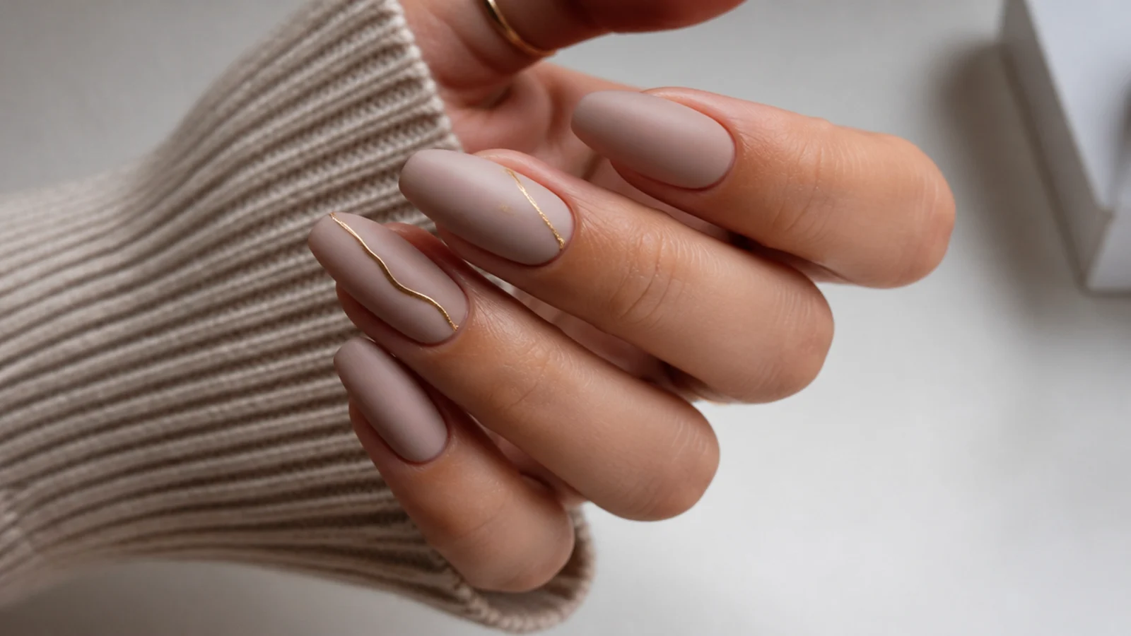Cool-toned nude matte nails on a long almond shape