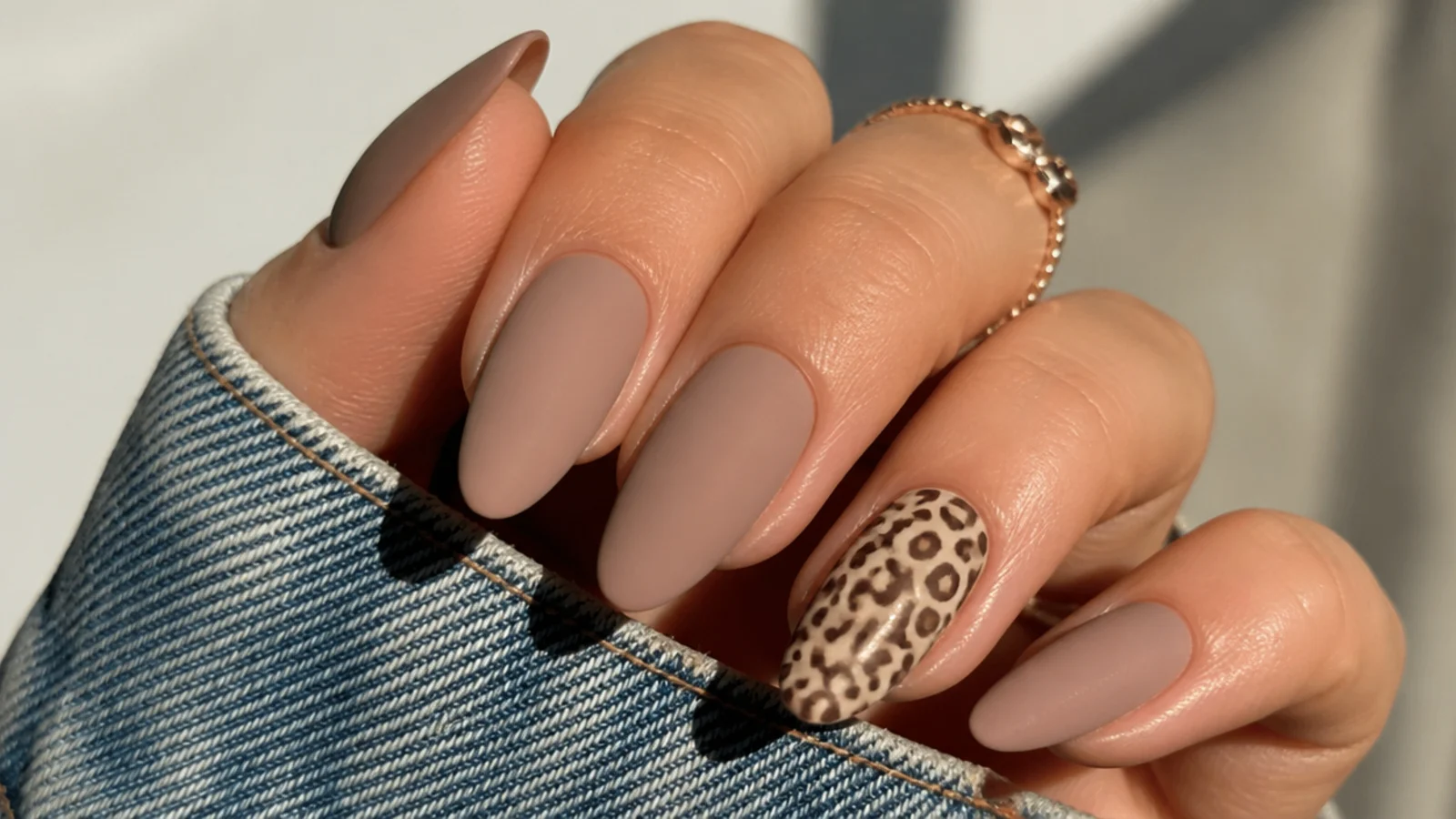 Matte nude nails with a soft brown leopard print accent nail