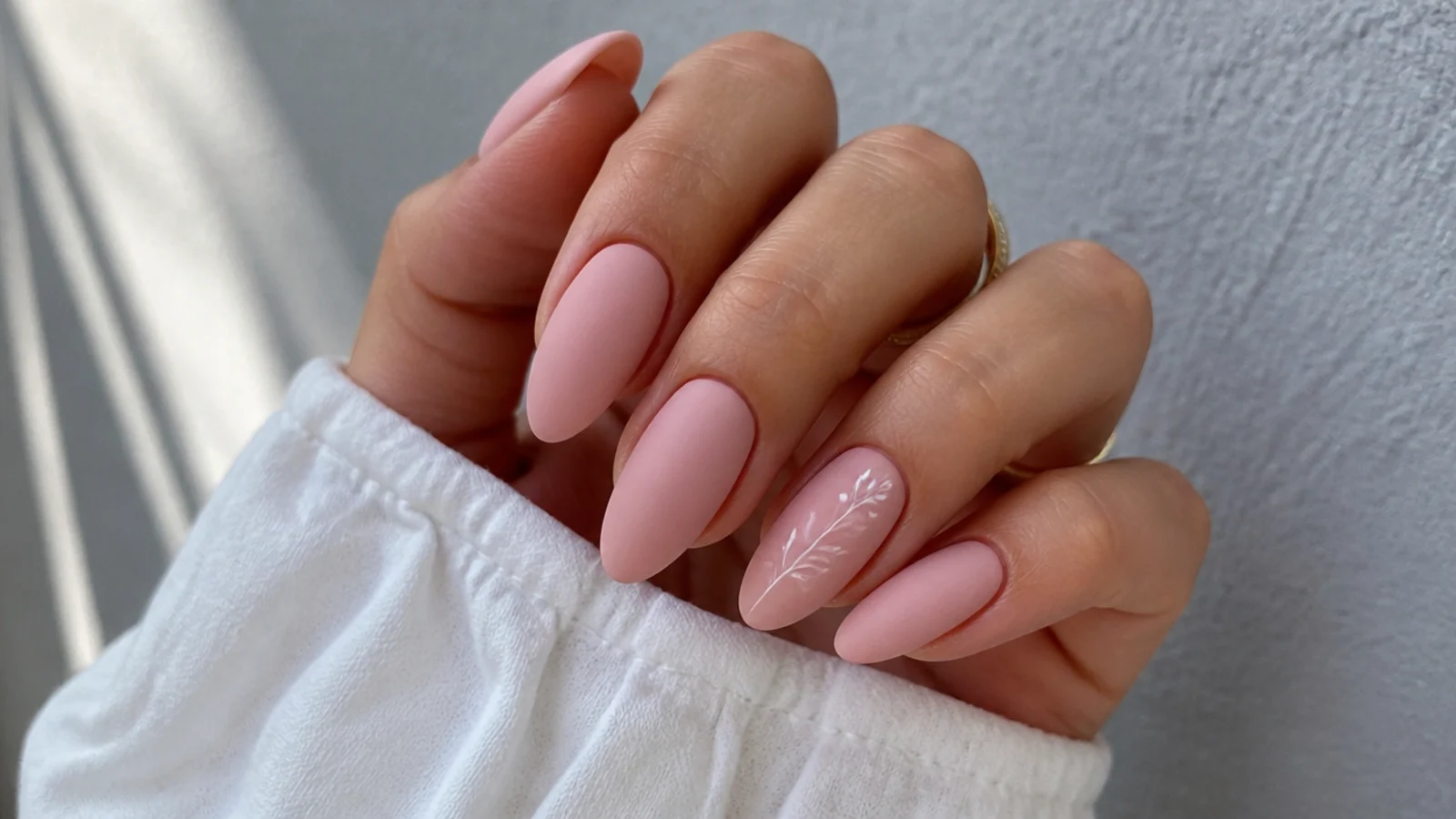 Soft pink matte nails on a long almond shape